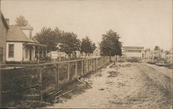 Street adjacent to house and fences Postcard