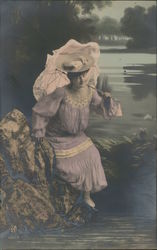 A picture of a Womand Holding a Umbrella by the River Postcard