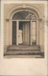 Woman Standing in Open Doorway of House Postcard