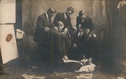 Men, Doctors?  Taking Pulse of Man Lying on Floor Postcard Postcard Postcard