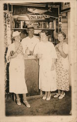 Three women at "Owl Bar", bartender posing behind Postcard