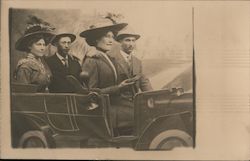 Two couples in an early model car Postcard