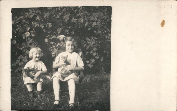 Two Girls Sitting on Chairs Holding Cats Postcard