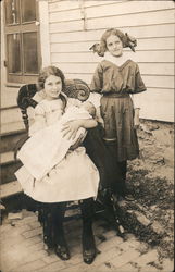 Two Young Girls Posing with a Baby Postcard