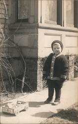 Young Boy on Sidewalk with Toy Postcard