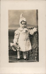 Baby with Bonnet and Teddy standing on chair Postcard