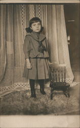 Girl in Dress Standing next to Chair Postcard