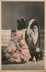 Geisha applying makeup in a mirror Japan Postcard Postcard Postcard