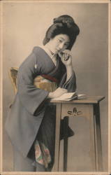 Geisha standing at a table Postcard