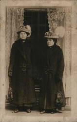 Two women in long dark coats Postcard