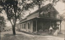 1908 Man and Woman Posing in Front of Residence Postcard