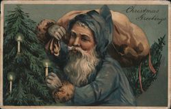 Santa Claus Dressed in Blue decorating Tree With Candles Postcard