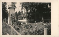 A Home w/ Wooden Water Tower, Rose Bushes Postcard