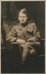 World War I Soldier Seated in Wicker Chair Postcard