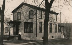 Woman Standing on Porch of Two Story House Postcard