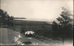 Lawn Chairs and Umbrella Overlooking the Water Postcard