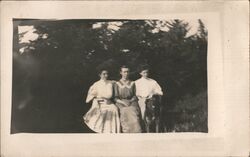 Three Women Posing Outdoors with Dog Postcard