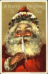 Santa, with holly encircling his hat, holds a quill Santa Claus Postcard Postcard