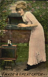 Woman fishing for pictures in fish tank Women Postcard Postcard