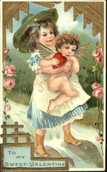 Girl in blue dress holding cupid Postcard