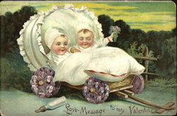 Two babies in flower wheeled wagon Postcard