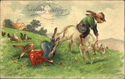 Two rabbits dressed as boys trying to ride a lamb Postcard