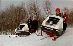 Snowmobiling in the snow with trees in background Postcard Postcard