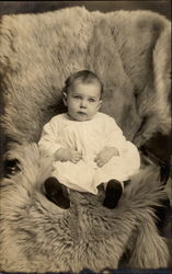 Baby on skin sitting up in chair Postcard