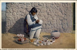 A woman of Isleta Decorating Pottery Postcard