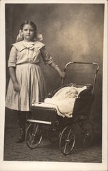 Girl standing next to baby in baby buggy Postcard