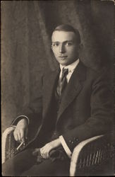 Man in Wicker Chair Holding A Cigarette Postcard