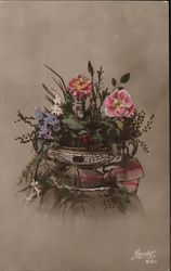 Pink, white, purple flowers and greenery in round container Postcard