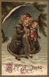 Two girls in coars holding umbrella and standing in the snow Christmas Postcard Postcard