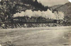 Steam Engine Traveling Along a River in the Mountains Postcard