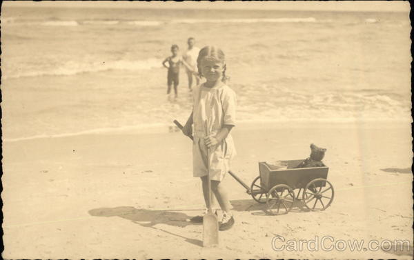 Two Children in the Ocean & One on the Beach with her Toys