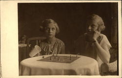 Two Girls playing a Board Game Postcard