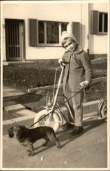 Little Girl with Scooter holding Dachshund on Leash Postcard