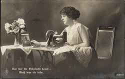 Woman at Sewing Machine Gazing Fondly at Photograph of Man in Uniform Couples Postcard Postcard