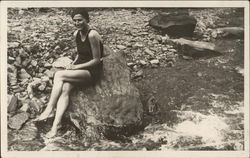 Woman Sitting on Rock Beside Rushing Water Postcard