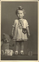 Very Young Girl in Embroidered Dress with Teddy Bear and Book Girls Postcard Postcard