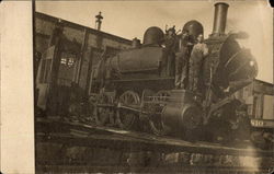 Three Men on Locomotive at Station Postcard