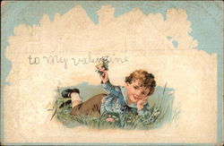 A small boy lying in a garden Postcard