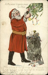 Santa hanging decorations with gray bag of toys Postcard