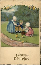 Three Children With Bunny, Chicks, and Basket of Colored Eggs Postcard