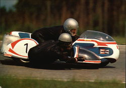 Two People Racing Very Small Motorcycle Car with a Sidecar Postcard