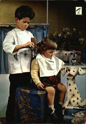 A picture of a boy pretending to be a haidresser and a girl pretending to be his customer Barbers Postcard Postcard