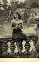 Woman holding roses, waterfall in background Postcard