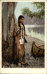 Indian Maiden in Traditional Outfit Stands by Canoe Postcard