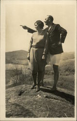 Man and woman on rock, man pointing Postcard Postcard