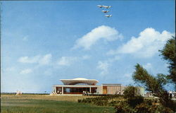 Modern Aircraft Over the Visitor Center, Wright Brothers National Memorial Outer Banks, NC Postcard Postcard